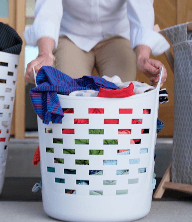 Laundry basket filled with unfolded clothes waiting to be washed, representing the recurring task at the center of the decision this guide helps you make