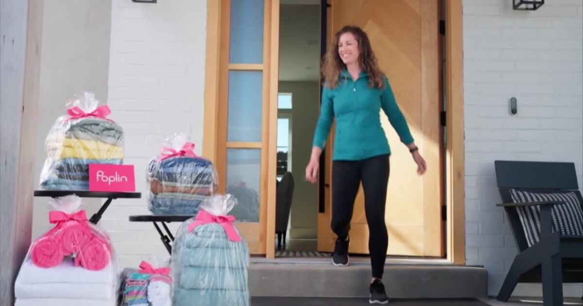 A woman walking out her front door past bundles of laundry wrapped and ready for Poplin pickup.