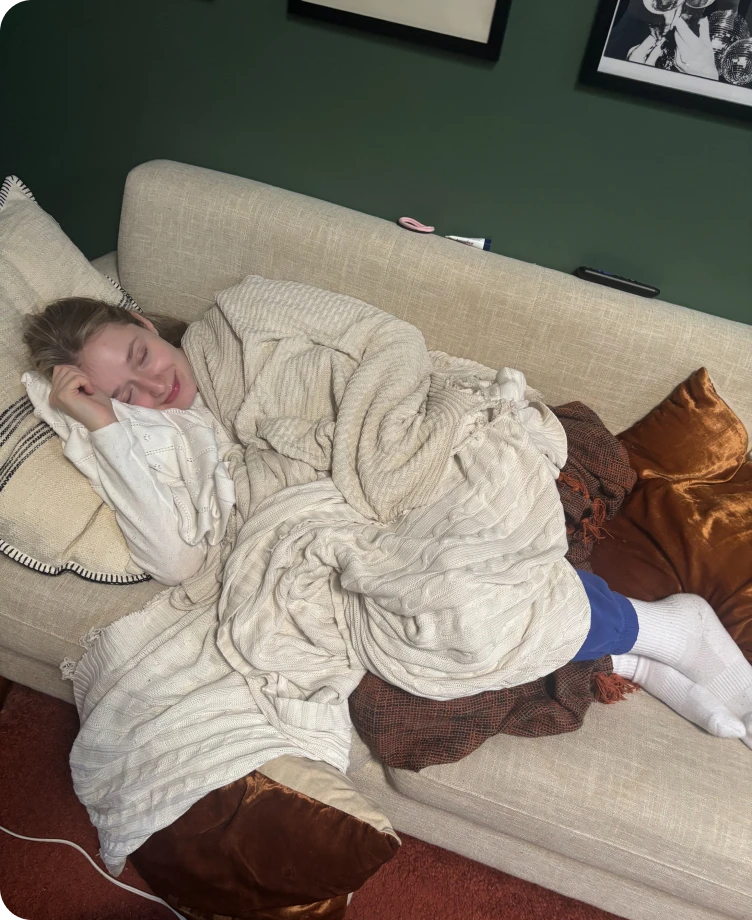 Olivia napping under a cozy blanket on the couch